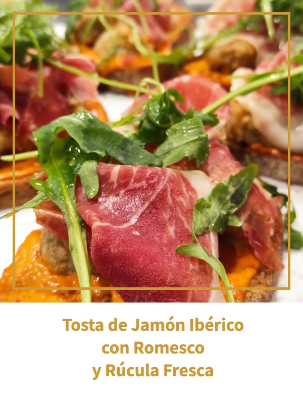 Tosta de Jamón Ibérico con Romesco y Rúcula Fresca